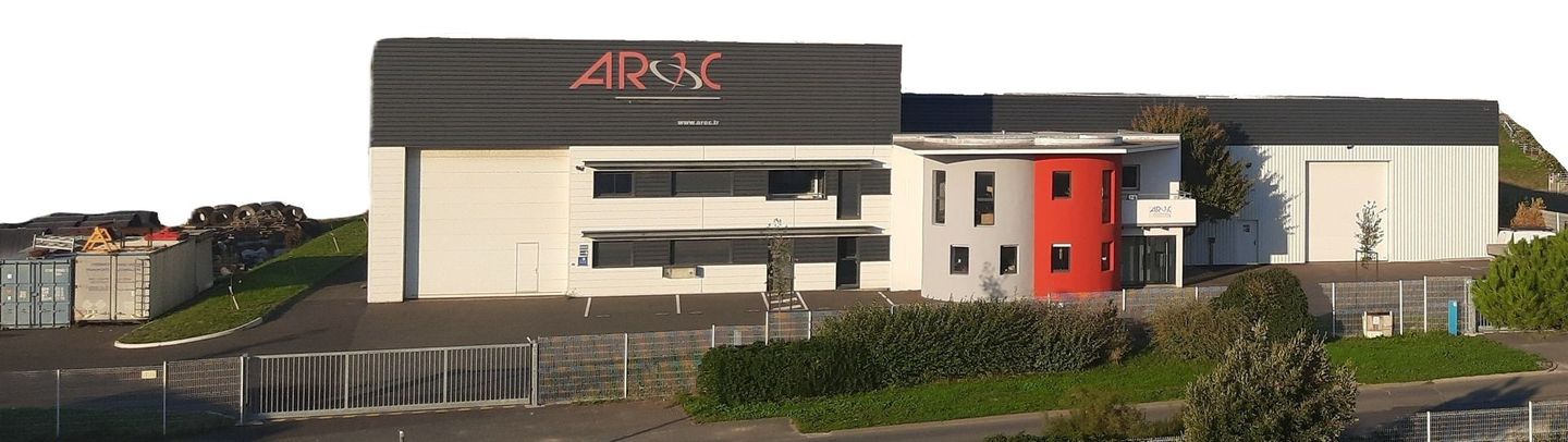 Un bâtiment au toit gris foncé et à la façade blanche et rouge.