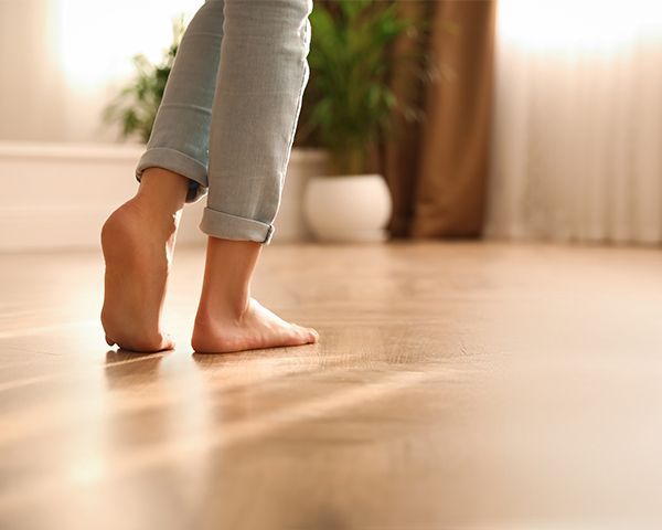 Photographie de pieds nus d'une femme sur un plancher chauffant