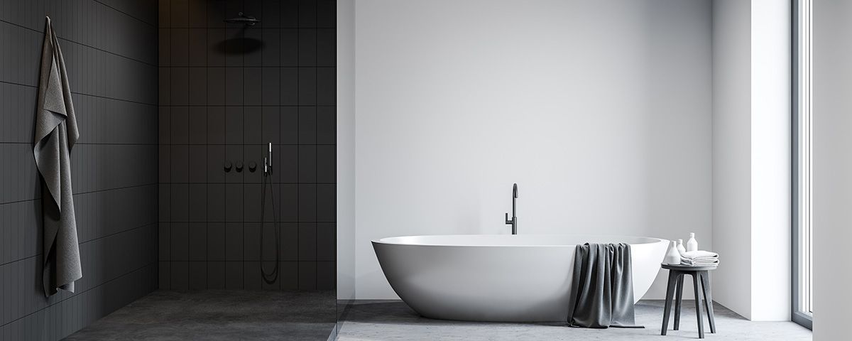 Photographie d'une salle de bains moderne noire et blanche avec baignoire et douche