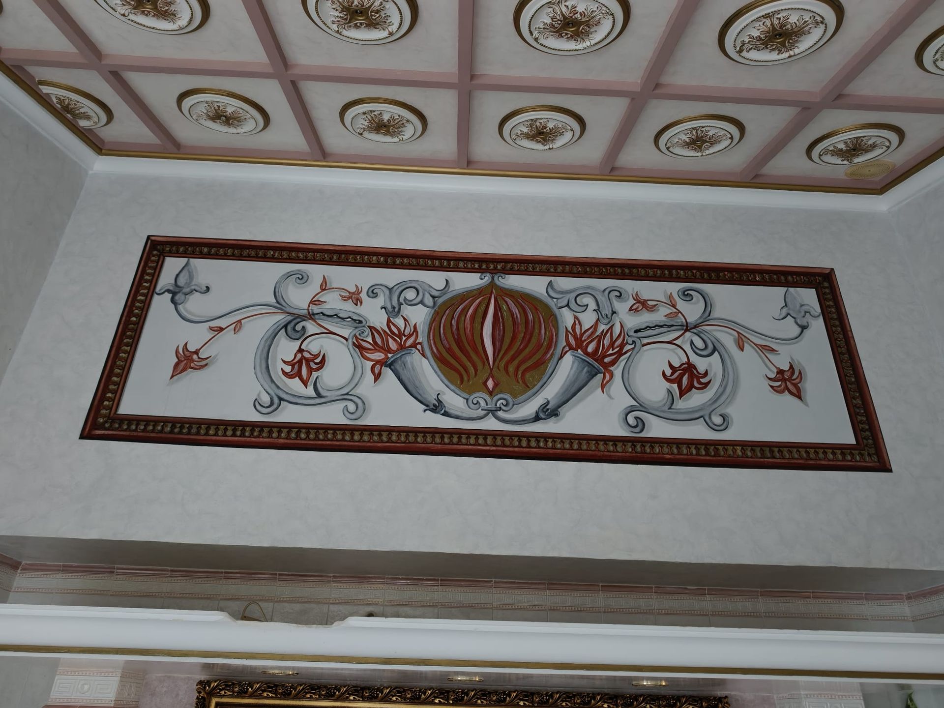 Panel decorativo de techo con un elaborado motivo floral y un adorno redondo central a rayas.