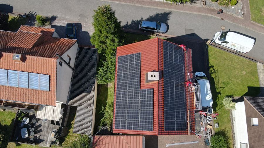 Eine Luftaufnahme eines Hauses mit Solarmodulen auf dem Dach.