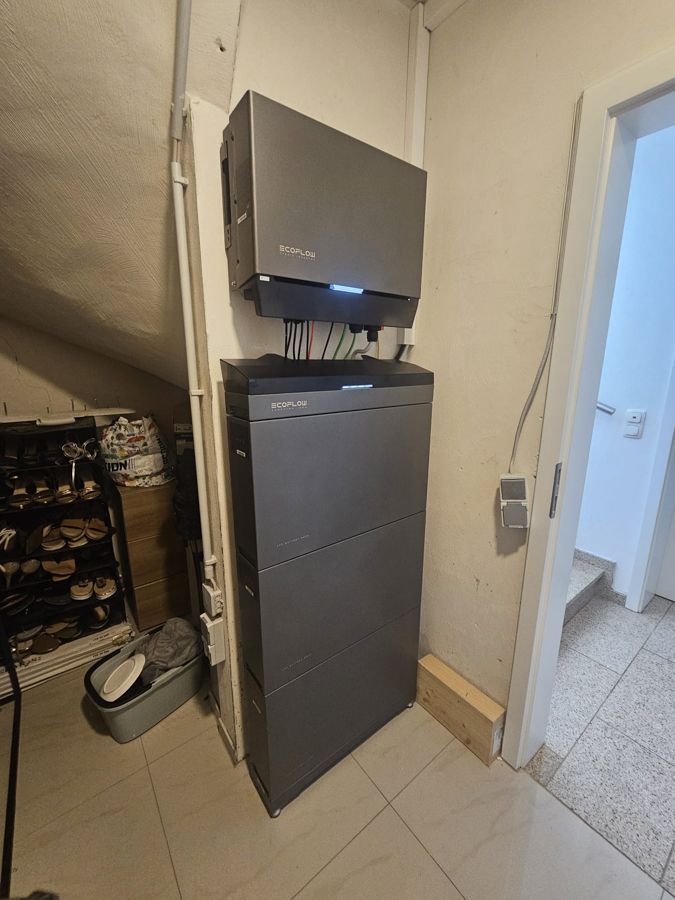 Eine große schwarze Kiste steht oben auf einer Wand in einem Raum.