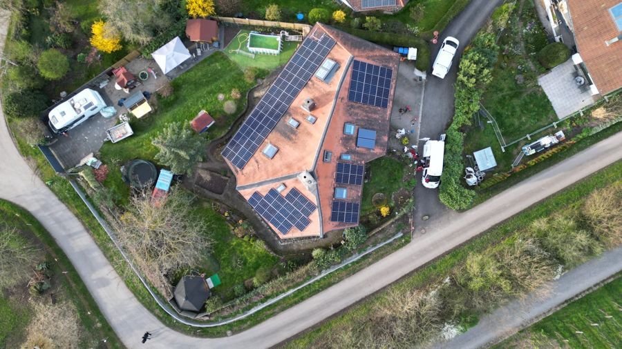 Eine Luftaufnahme eines Hauses mit Solarmodulen auf dem Dach.