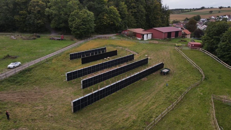 Eine Luftaufnahme einer Reihe von Solarmodulen auf einem Feld.