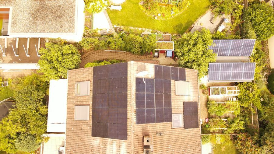 Eine Luftaufnahme eines Hauses mit Solarmodulen auf dem Dach.