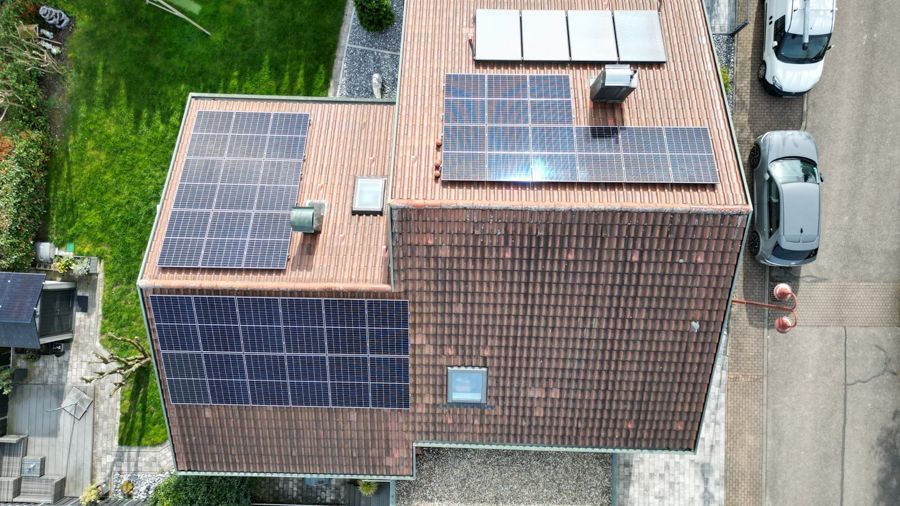 Eine Luftaufnahme eines Hauses mit Solarmodulen auf dem Dach.