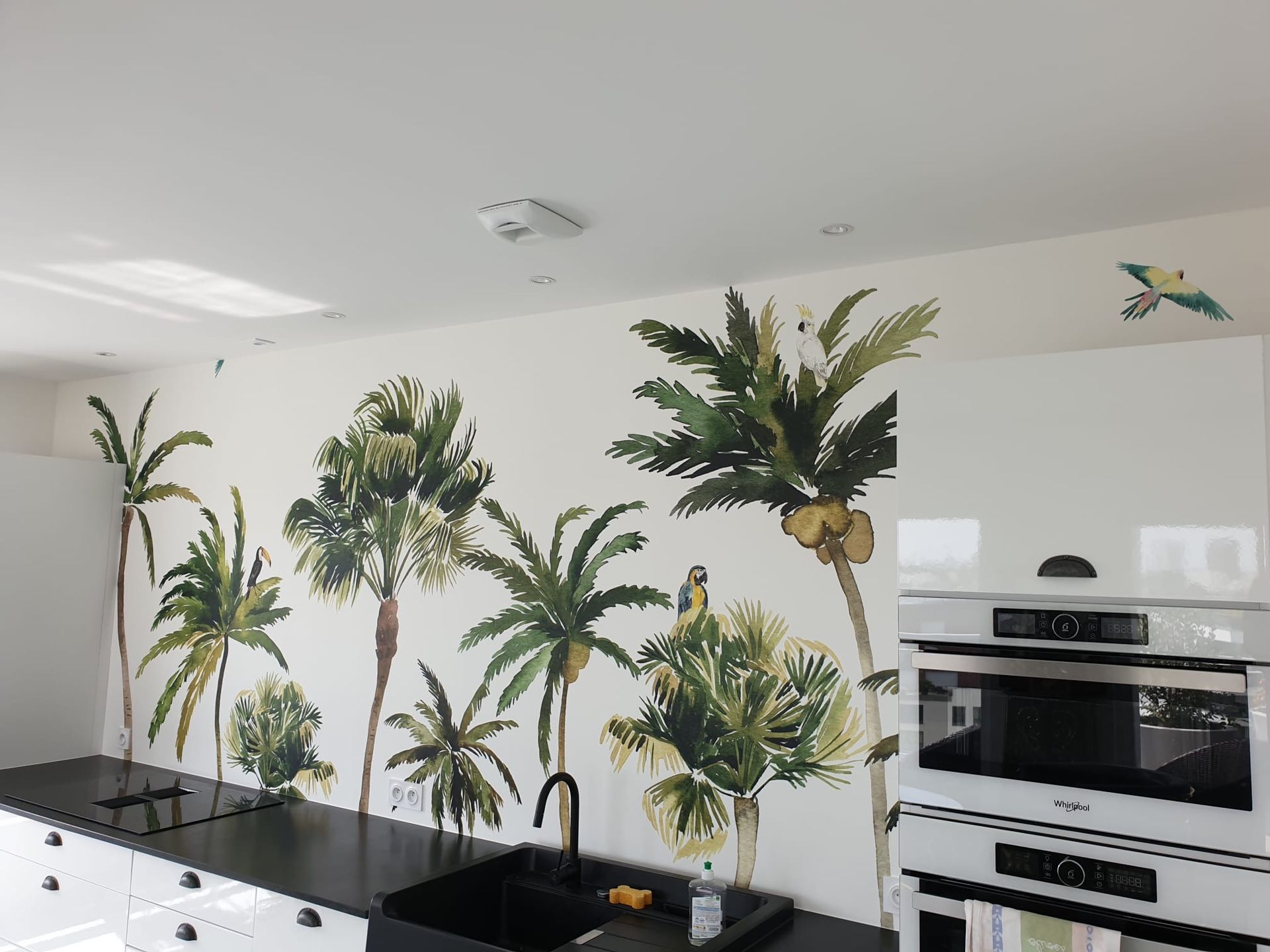 Papier peint de palmiers dans une cuisine au dessus d'un plan de travail