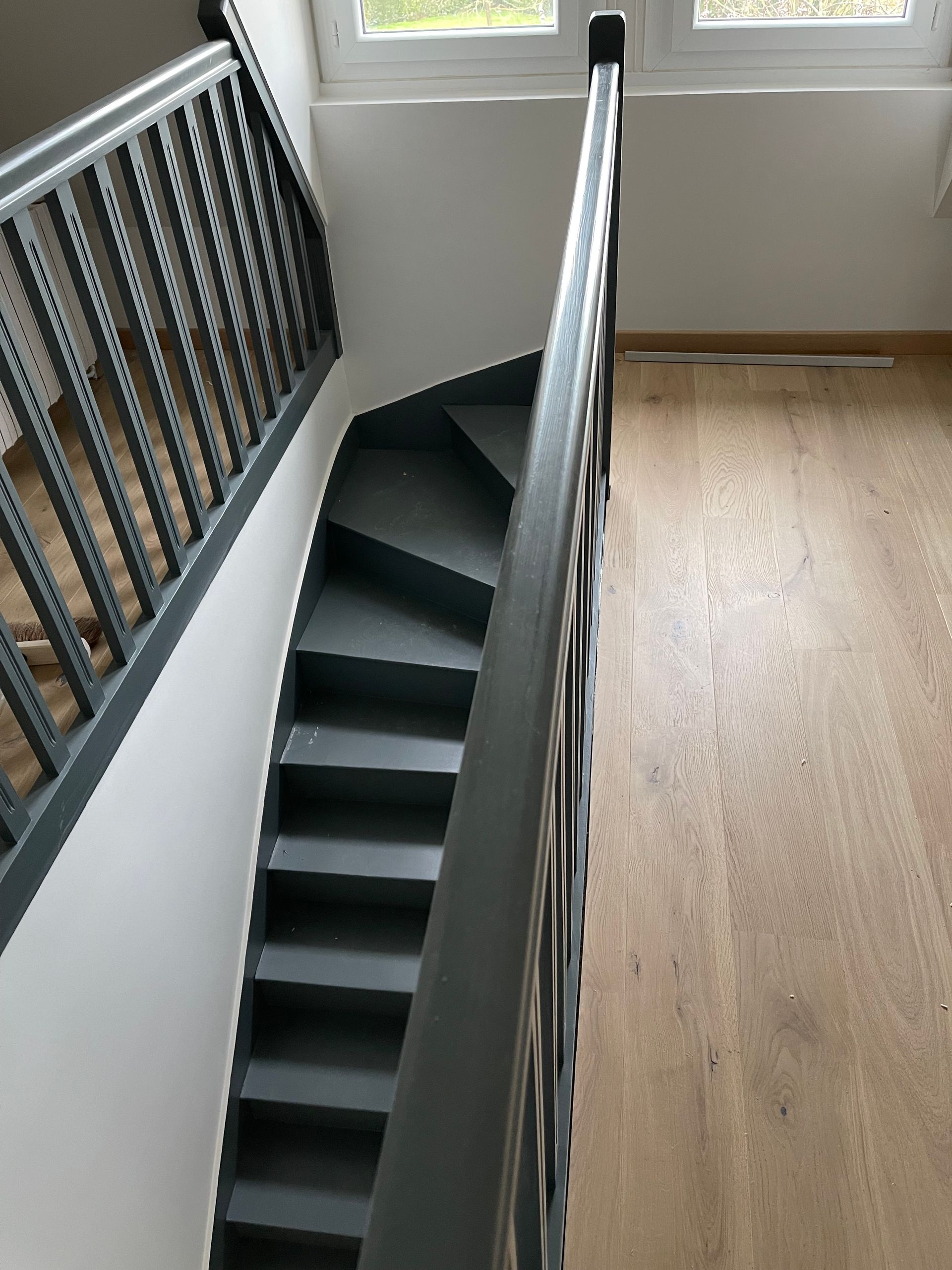 Peinture d'un escalier en noir et revêtement de sol en parquet