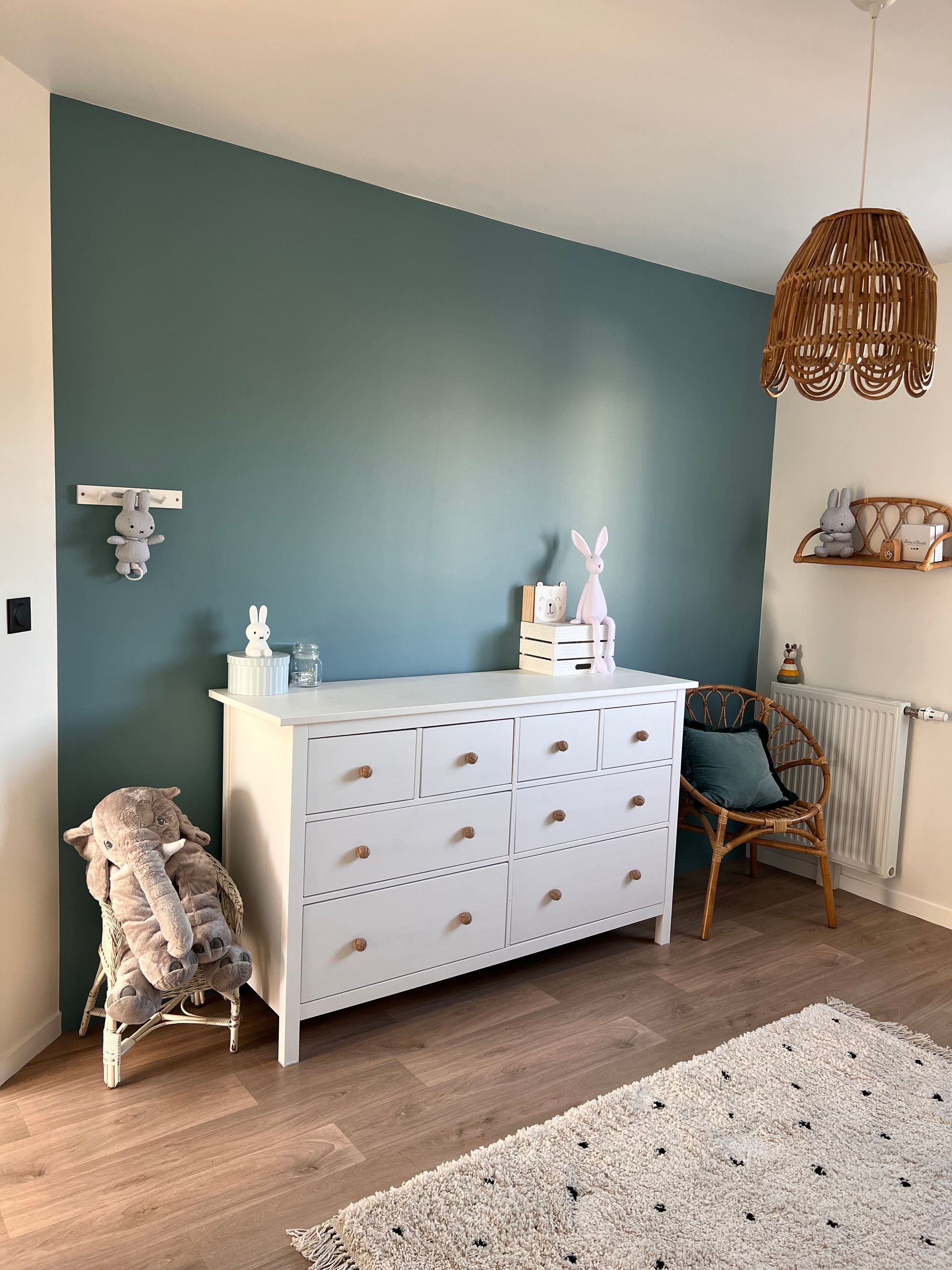 Décoration d'une chambre d'enfant avec une commode blanche et une peinture bleue