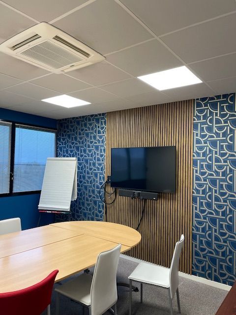 Télévision accrochée devant un bandeau en Panelio dans une salle de réunion