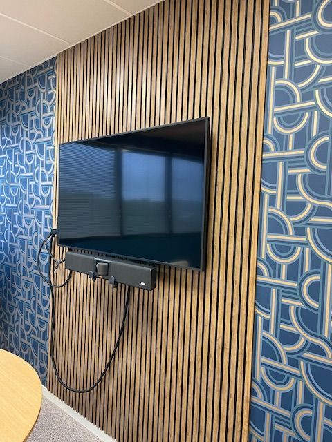 Télévision accrochée devant un bandeau en Panelio