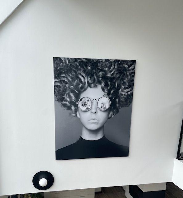 Décoration d'un mur avec une peinture en noir et blanc d'une femme avec des lunettes