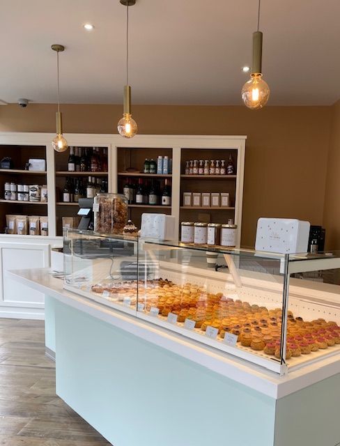 Décoration d'une boutique de pâtisseries avec un présentoir blanc et vert pâle