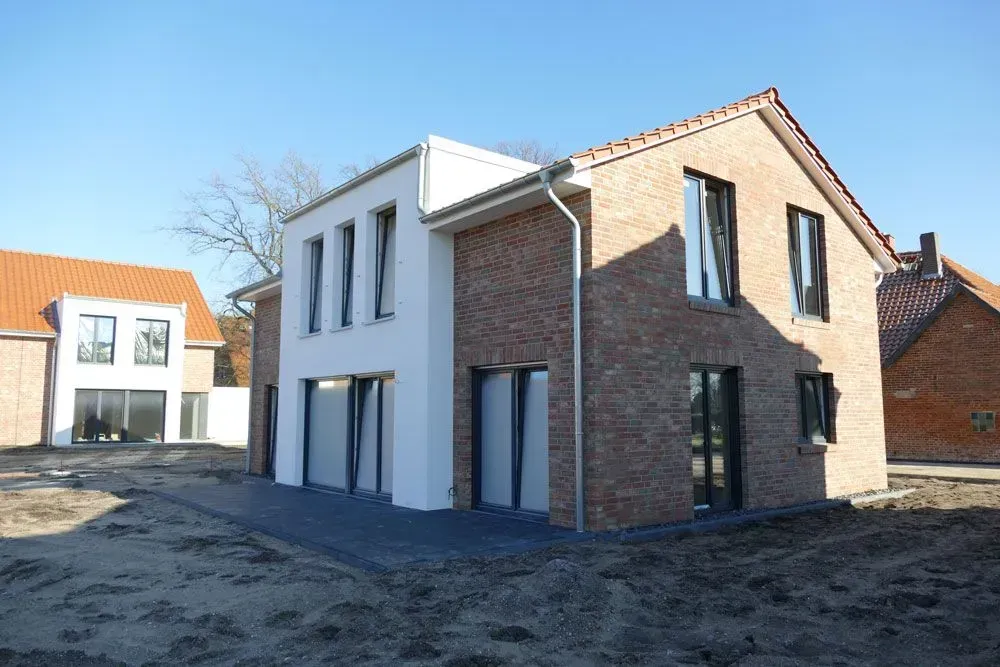 Moderne Backstein- und weiße Häuser im Bau an einem sonnigen Tag