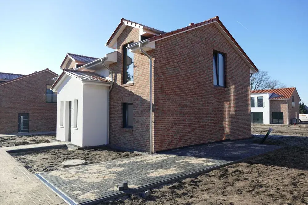 Neue Backsteinhäuser entstehen in einer sonnigen Wohnstraße
