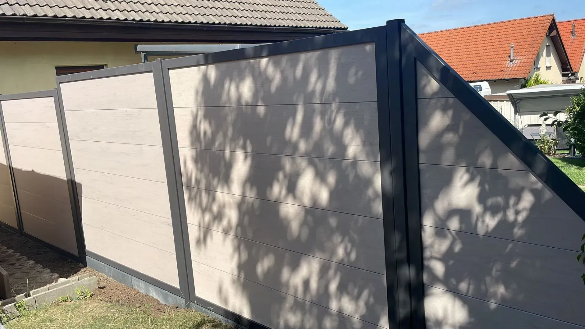 Referenzbild: Gartenzaun mit Sichtschutz aus sehr hellem Holz mit schwarzen Metallrahmen