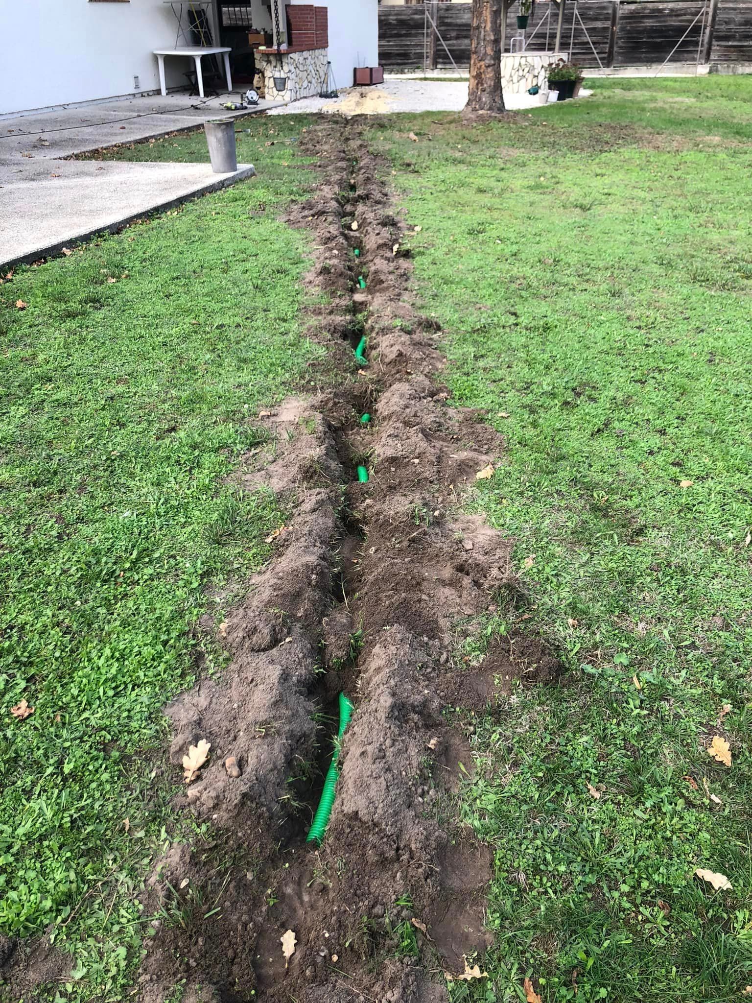 Tranchée dans un jardin avec gaine verte