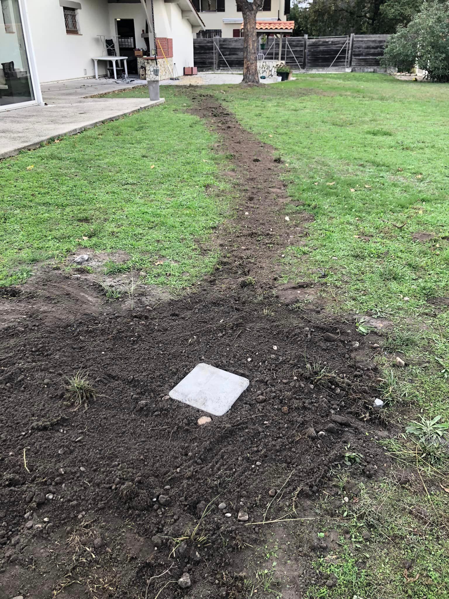 Tranchée bouchée dans un jardin avec un regard