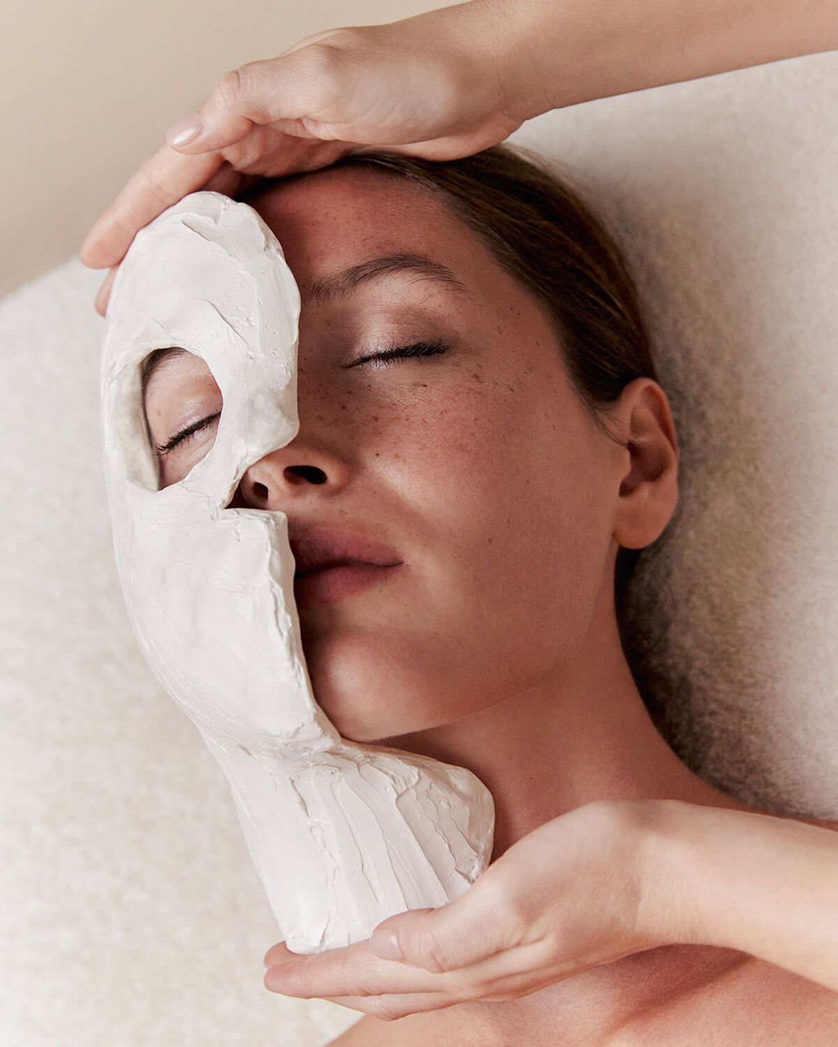 Mains en train de réaliser un soin du visage