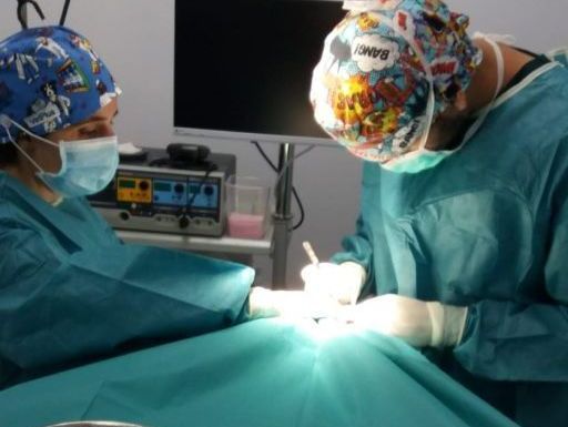 Dos cirujanos están operando a un paciente en un quirófano.