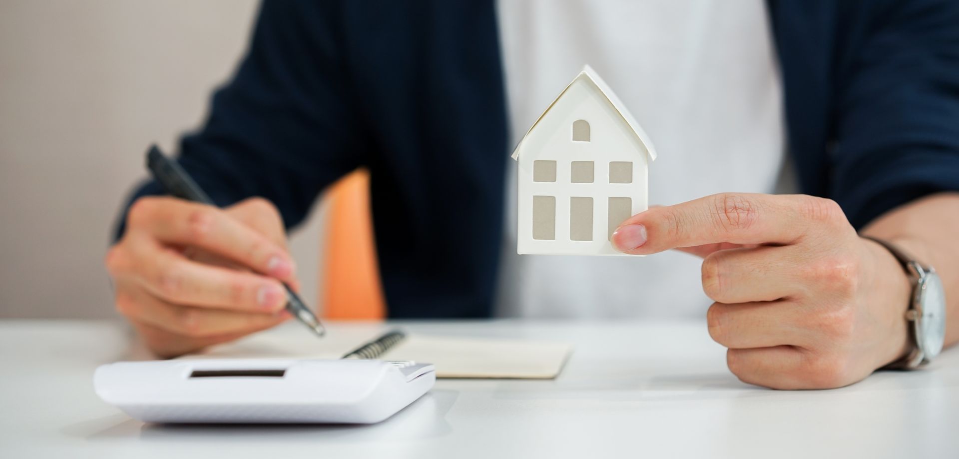 Un monsieur tient une maison pour un prêt immobilier