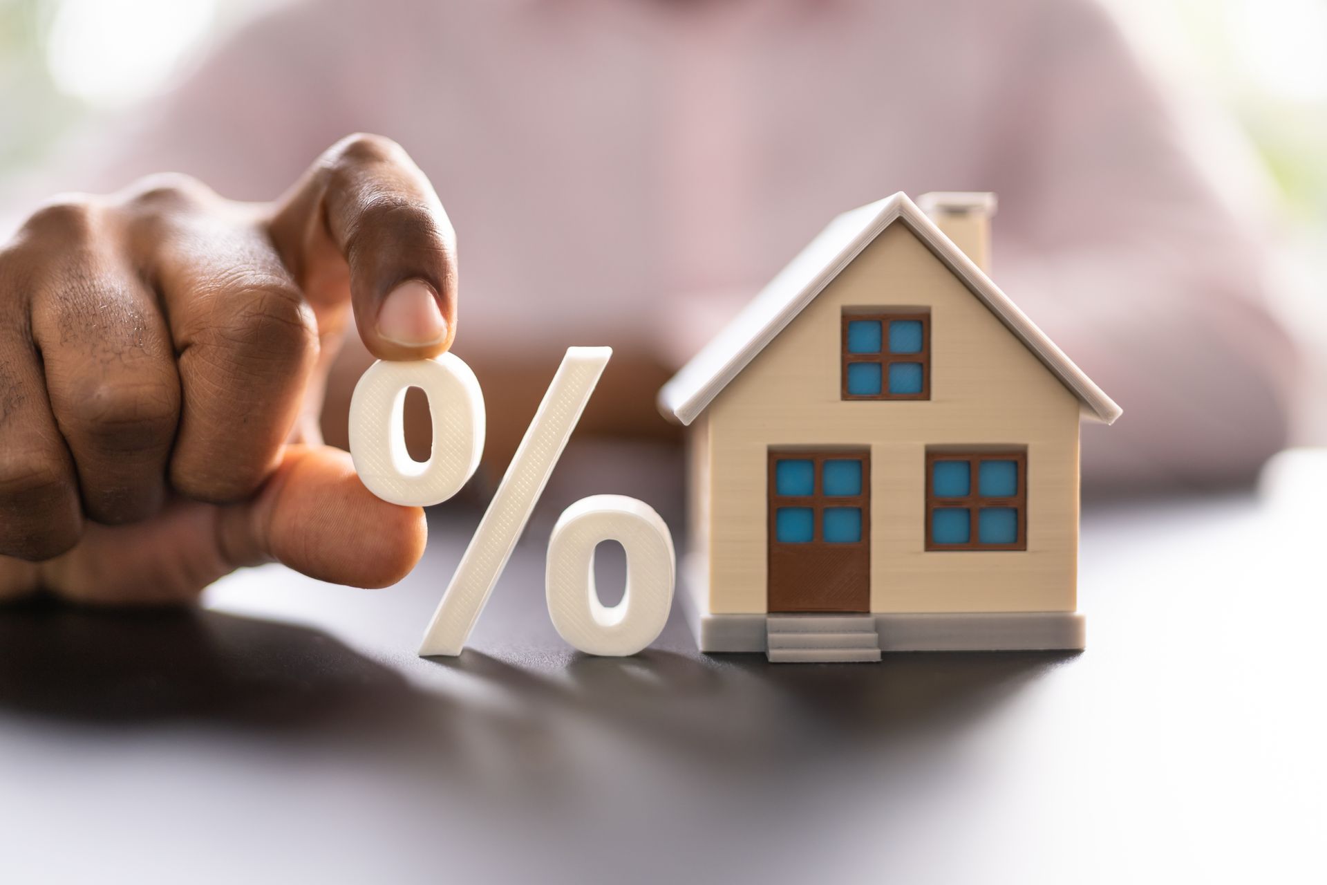 Une maison avec le sigle du pourcentage pour la négociation du taux