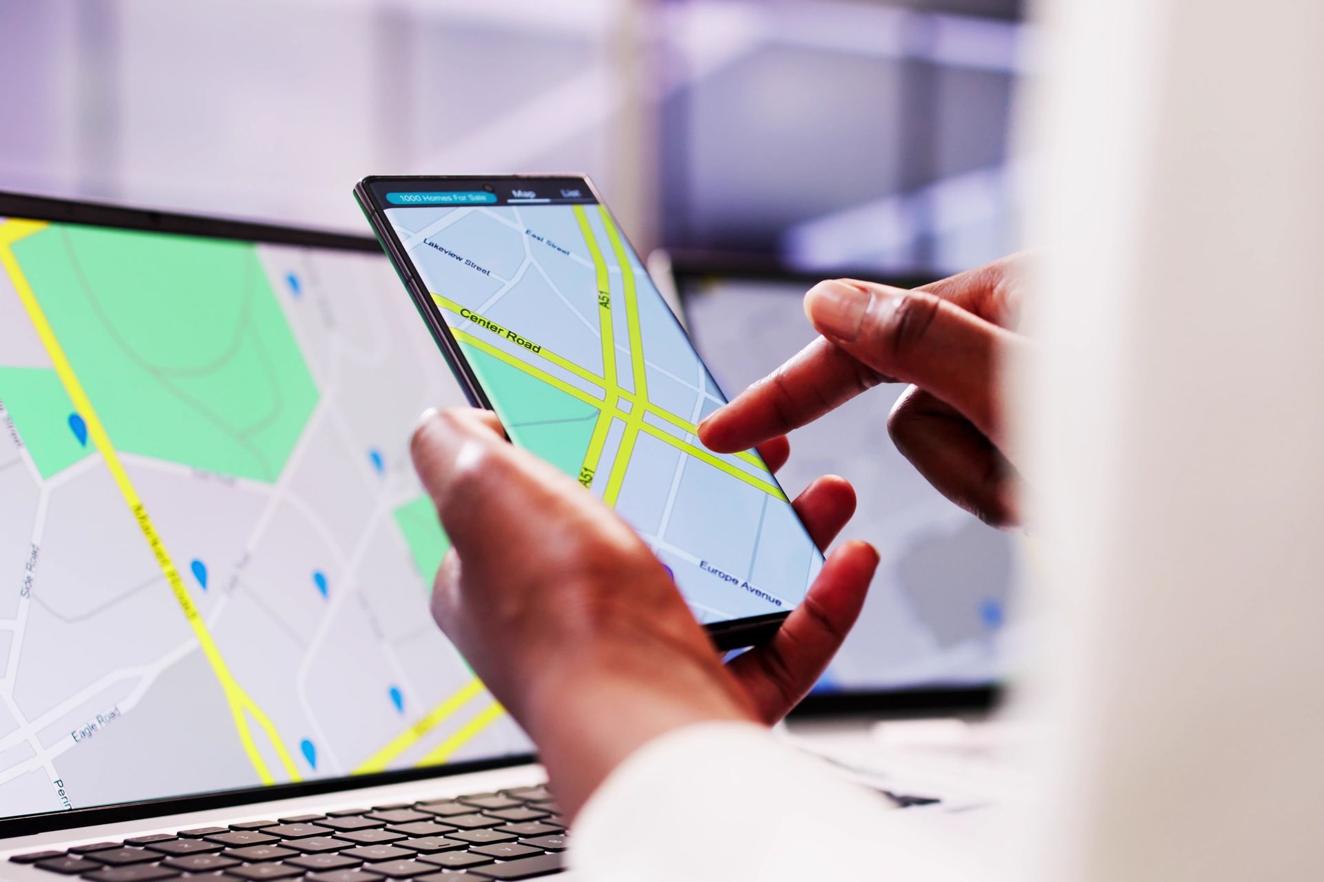 Une personne regarde sur son portable le bon emplacement pour investir en immobilier