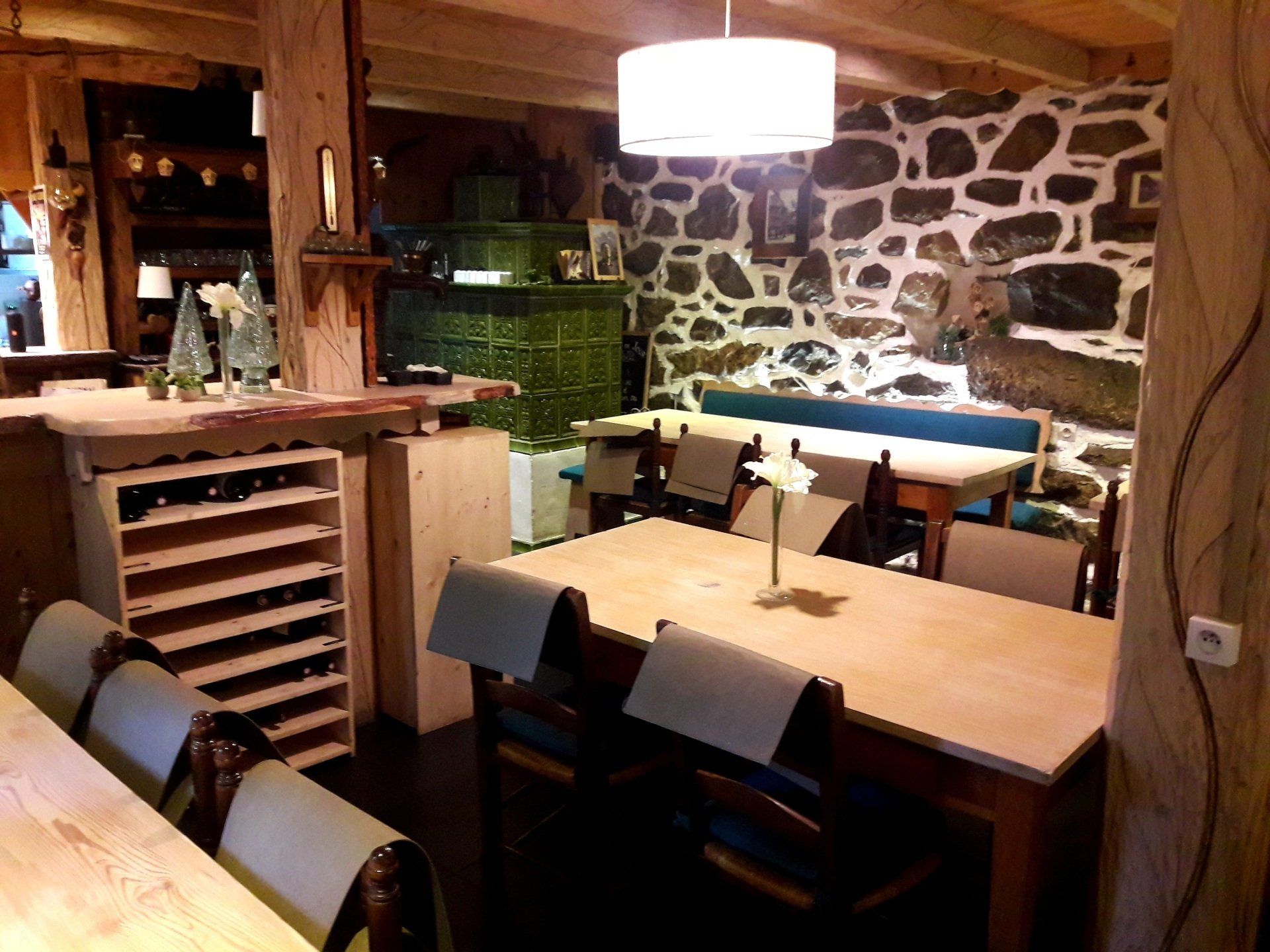 Salle de restaurant avec un comptoir, des tables et des bouteilles de vins