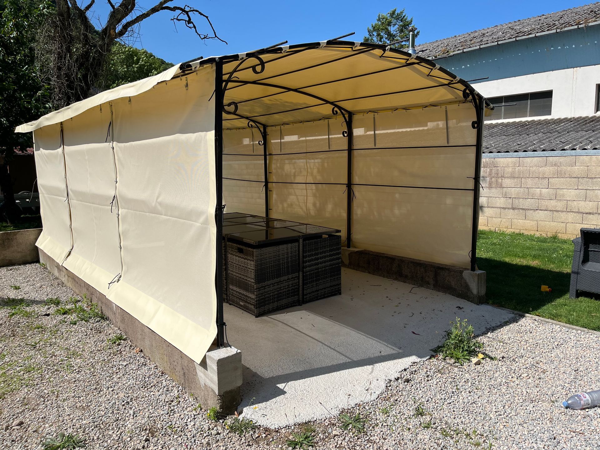 Gazebo d'extérieur beige ombragé avec structure métallique.