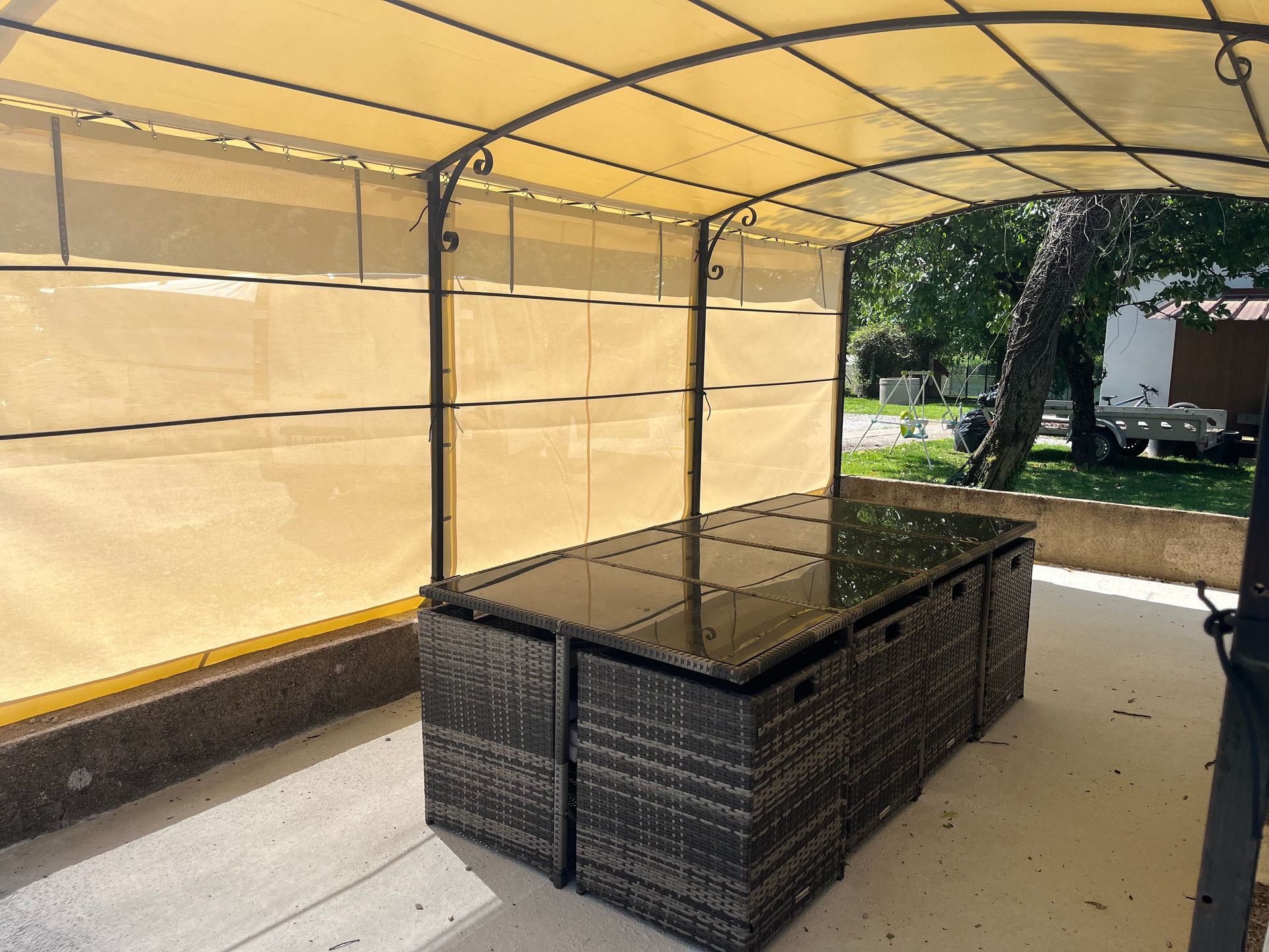 Ensemble de patio sous un auvent, sur une terrasse en béton.