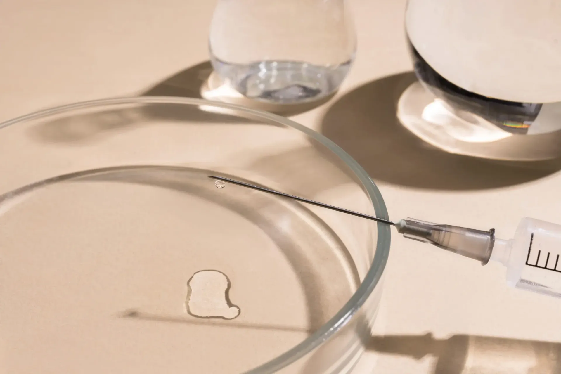 Una aguja de jeringa se cierne sobre una placa