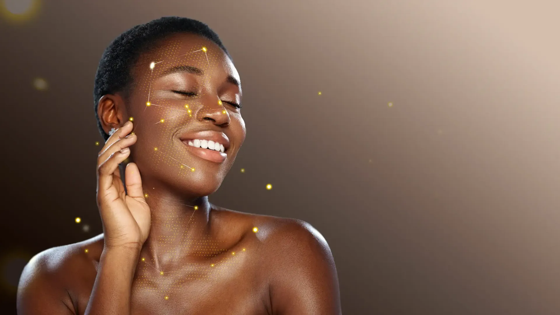 Una persona sonriente con piel radiante y destellos dorados, apoyando la mano en la mejilla sobre un fondo marrón.