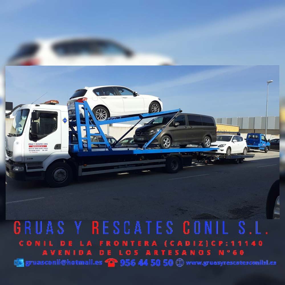 Tow truck carrying several vehicles, likely for rescue or transport in Conil de la Frontera, Cádiz, Spain.