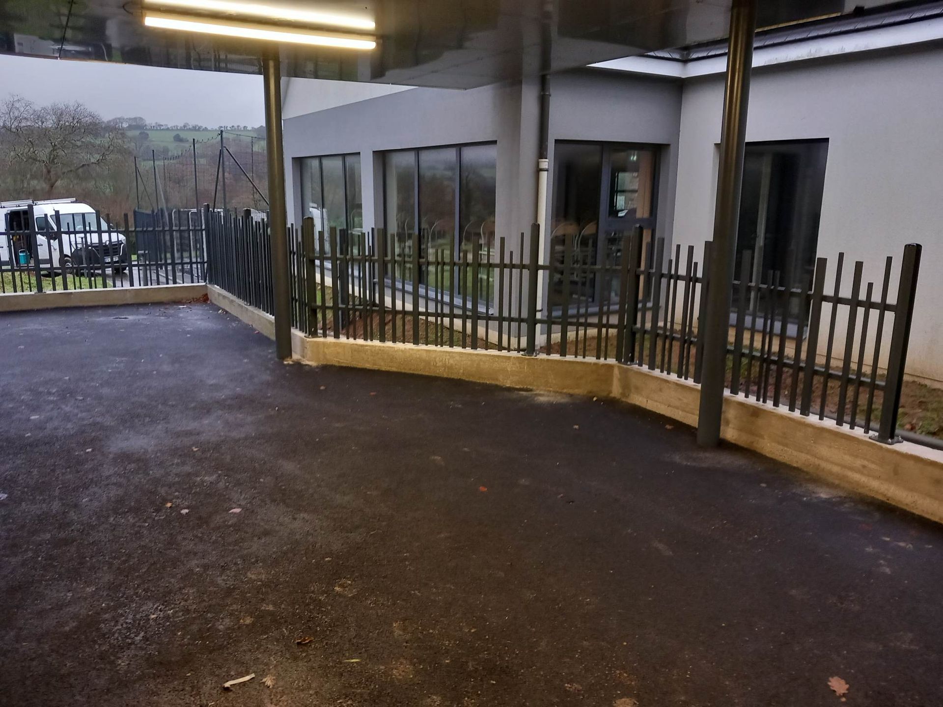 Clôture en bois à treillis entourant une pelouse verte, près d'une maison.