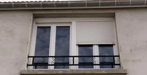 Fenêtres blanches fermées avec stores a demi fermés