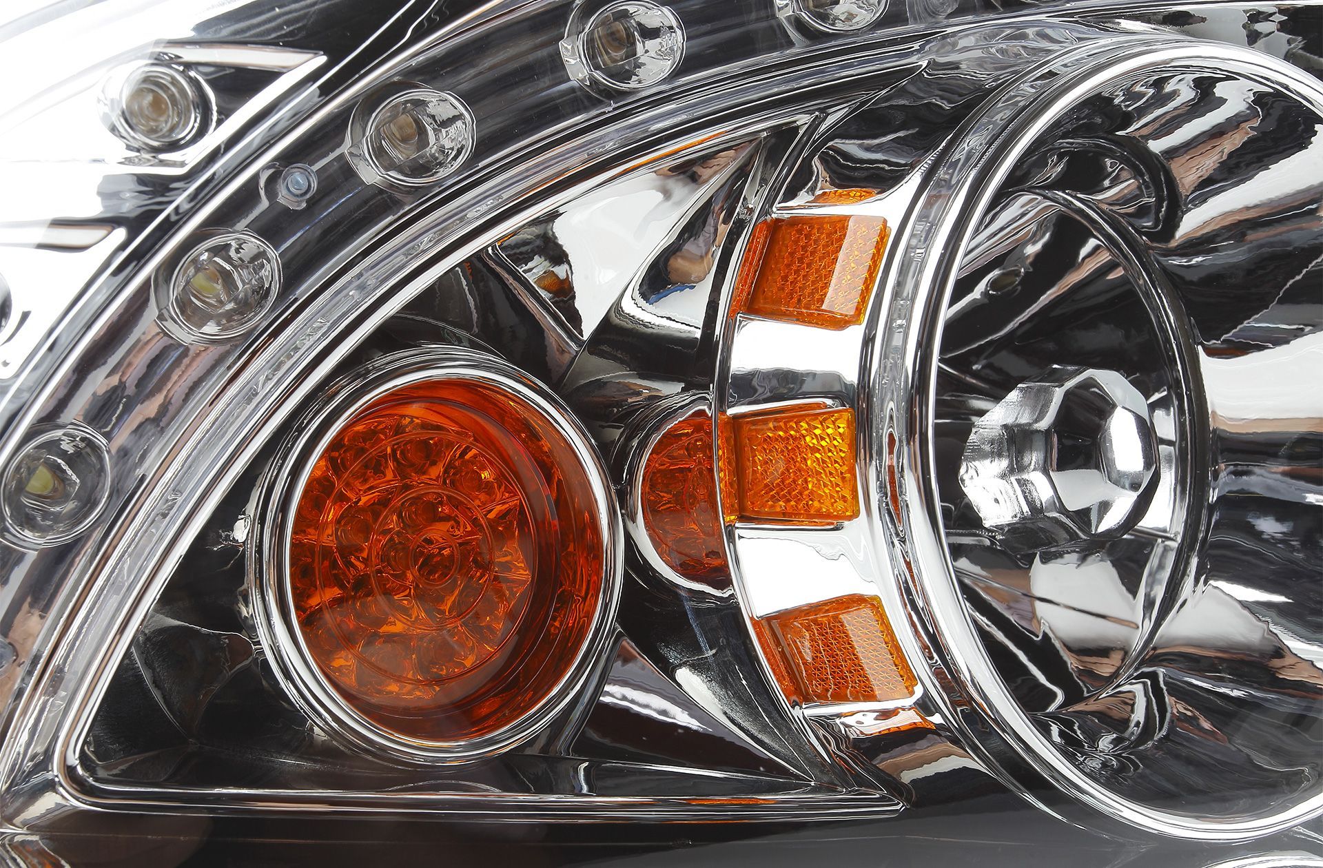 Três lâmpadas halógenas de farol automotivo sobre uma superfície branca.