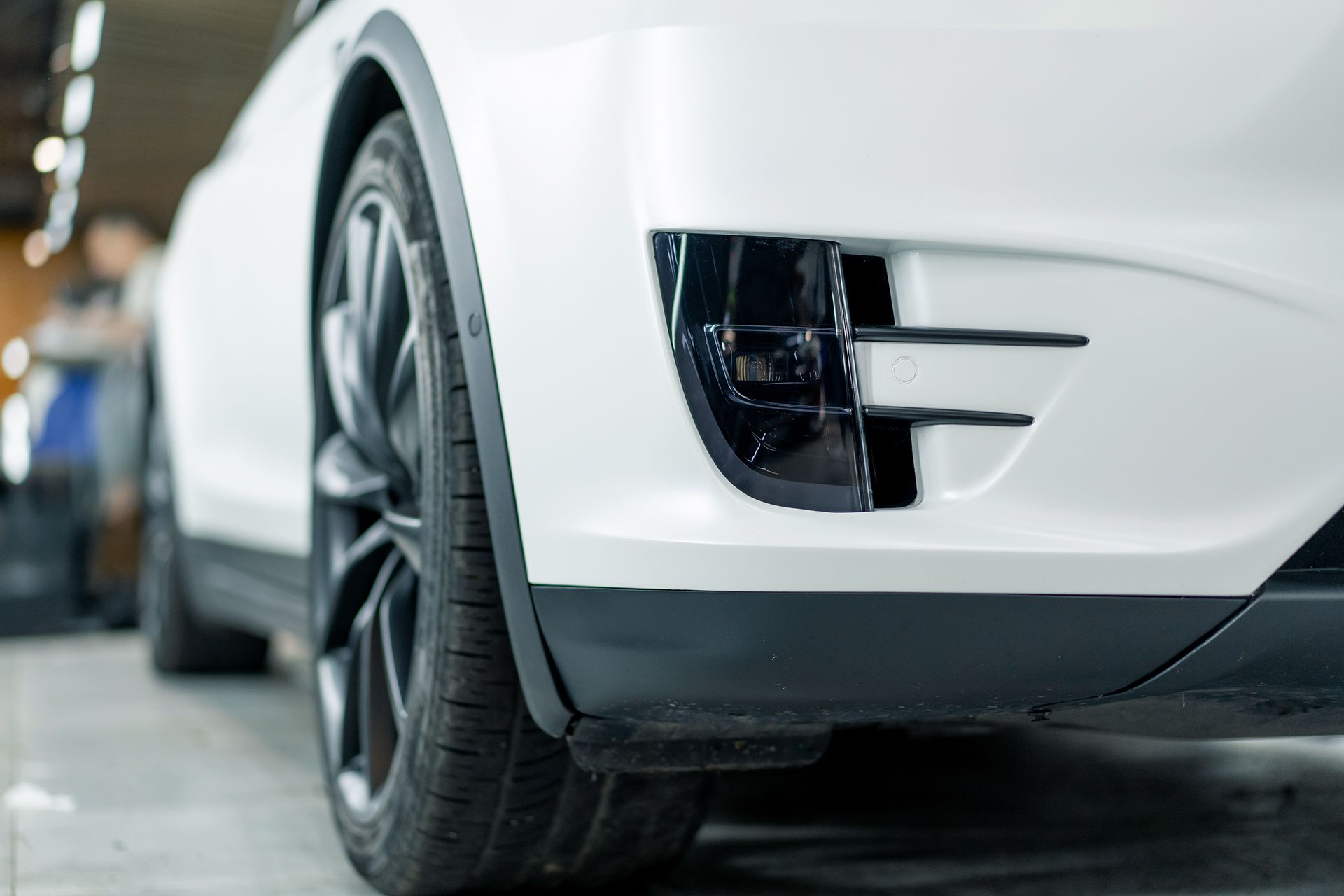 Oito pares de faróis de carro brancos e brilhantes contra um fundo preto.