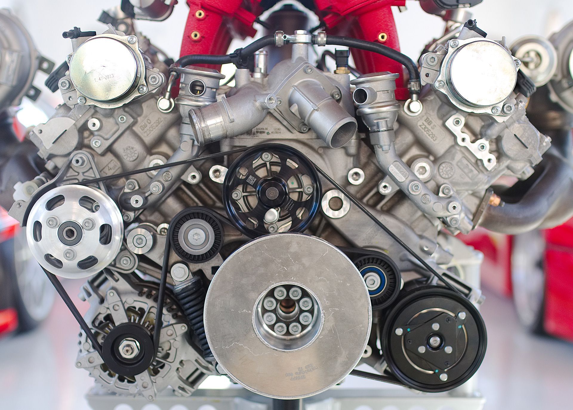 Motor cromado em carro vermelho, com filtro de ar, coletores de escape e acessórios cromados.