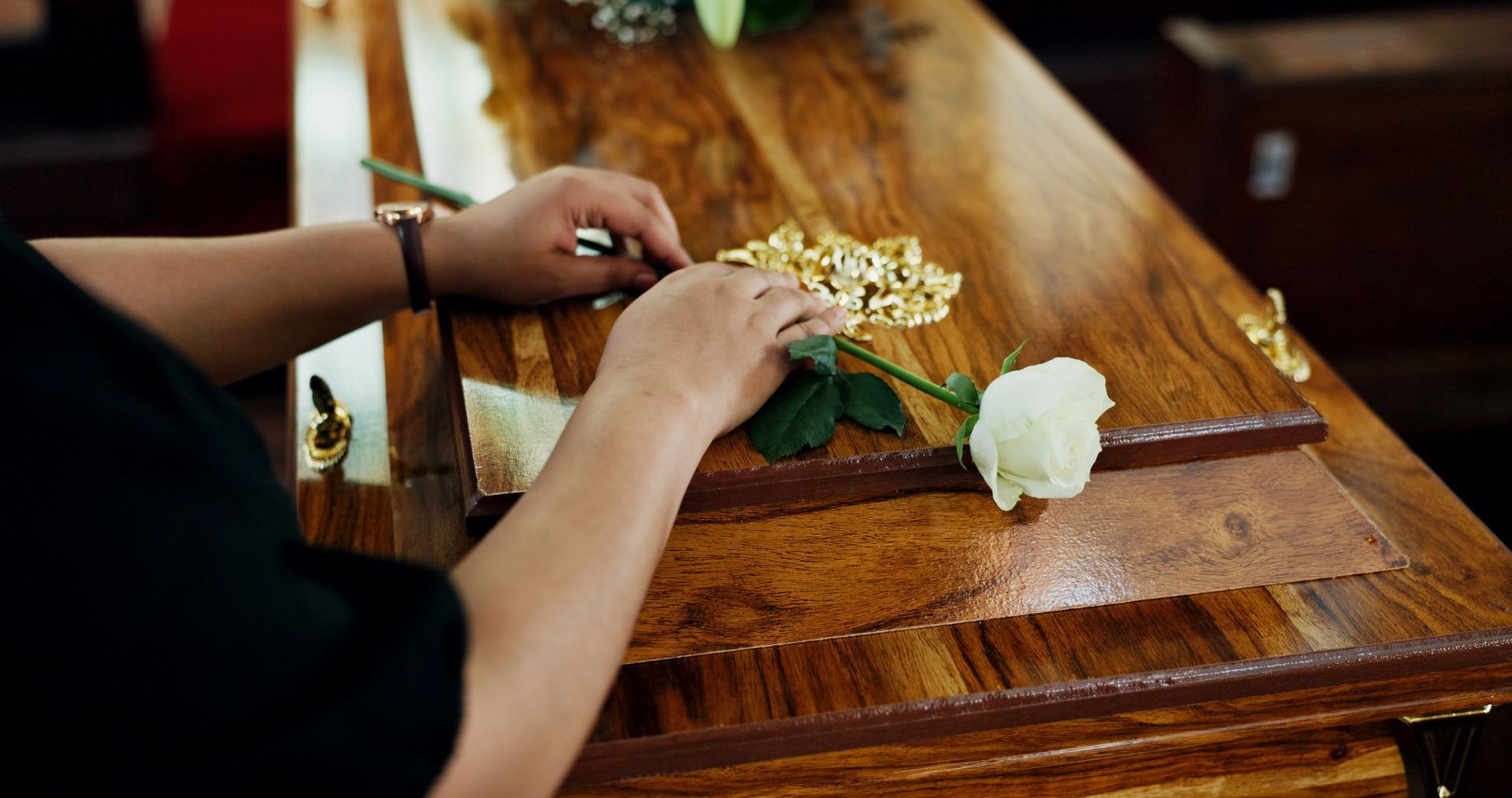 Femme posant une fleur blanche sur un cercueil