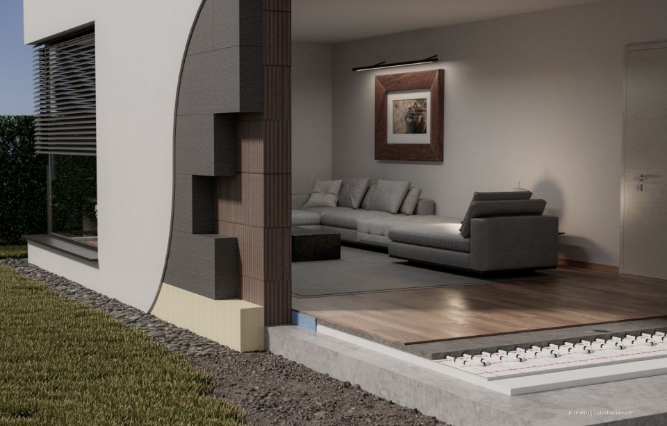 Außenansicht eines Gebäudes mit strukturierter grauer Stuckwand, Ziegelsteinen und einem Fenster mit einem granitähnlichen Kopfteil.