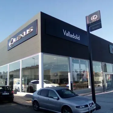 Un coche plateado está aparcado frente a un concesionario Lexus.