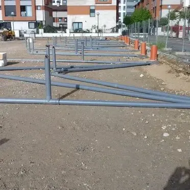 Una hilera de tuberías se encuentran tendidas en el suelo en un sitio de construcción.
