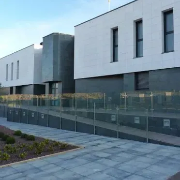 Un gran edificio con una valla de cristal a su alrededor.