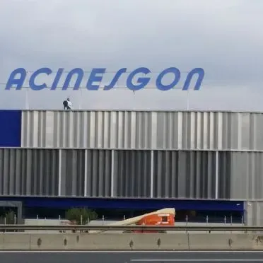 Un hombre está parado en el techo de un edificio con la palabra acinesgon en él.