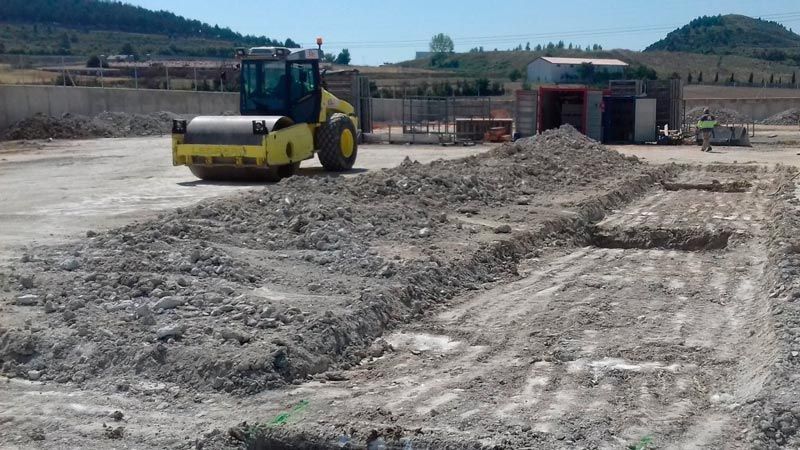 Un rodillo amarillo se desplaza por un campo de tierra.