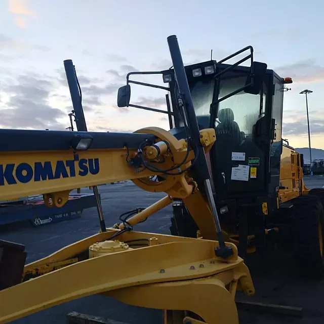 Un tractor Komatsu amarillo está estacionado en un estacionamiento.