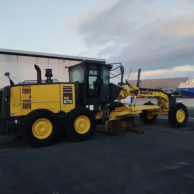 Un tractor Komatsu amarillo está estacionado en un estacionamiento.