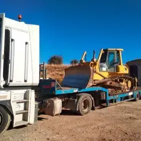Una excavadora está siendo transportada en un camión de plataforma.