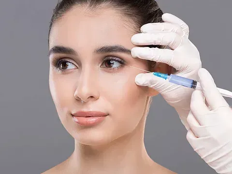 Una mujer recibe una inyección de botox en el ojo.