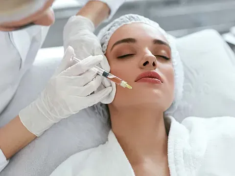 Una mujer recibe una inyección de botox en la cara.